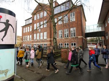 Billede af skolen med børn der går forbi